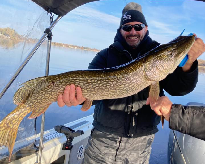inage of angler holding husge northern pike caught on lake of the woods