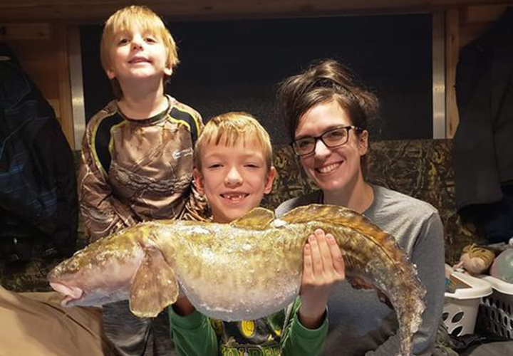 image of mother and sons holding huge eelpout caught on Lake of the Woods