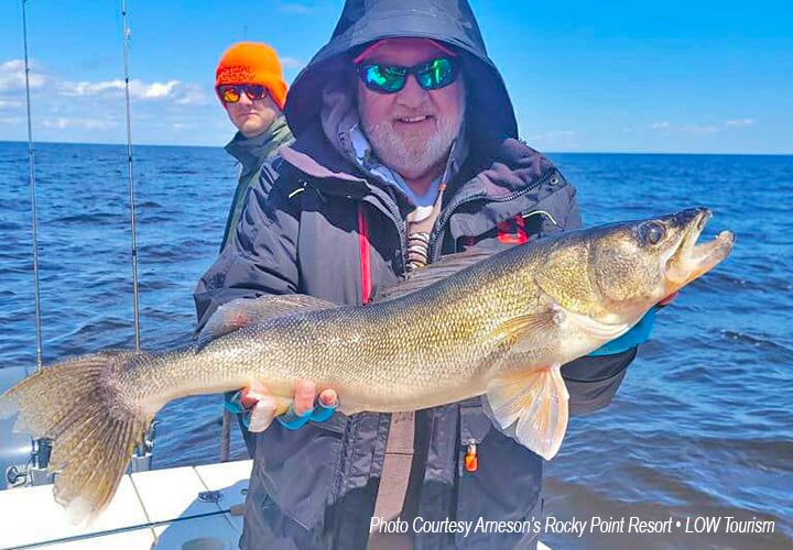 image of walleye fisherman holding large fish he caught on Arneson's Resort charter boat
