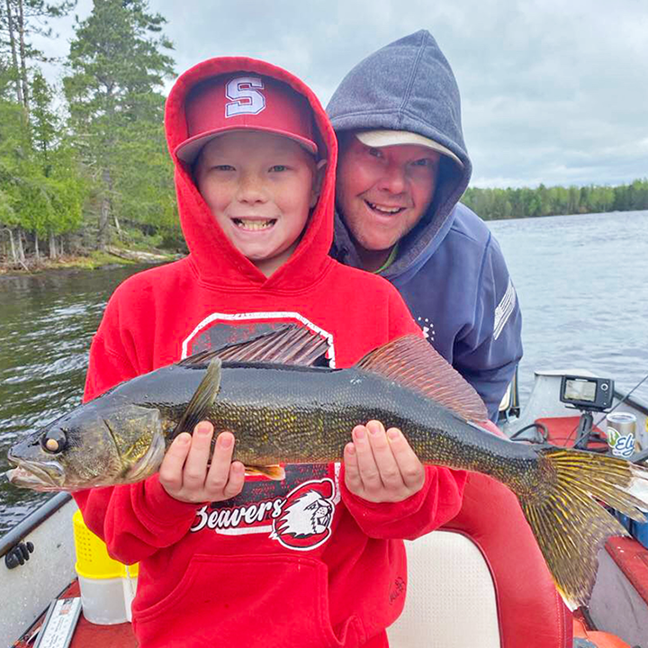 image of young boy holding big walleye caught on an Ely area lake