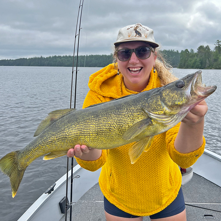 image of young woman with huge walleye she caught in the Ely MN region