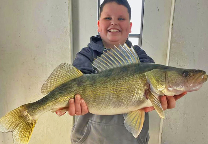 image of 13 year old boy holding huge walley he caught on lake of the woods