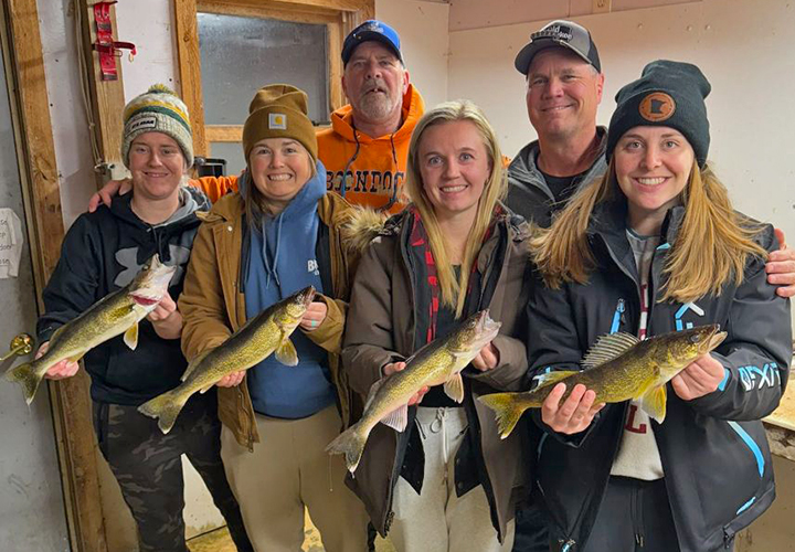 image of 4 women holding nice walleyes they caught ice fishing on lake of the woods