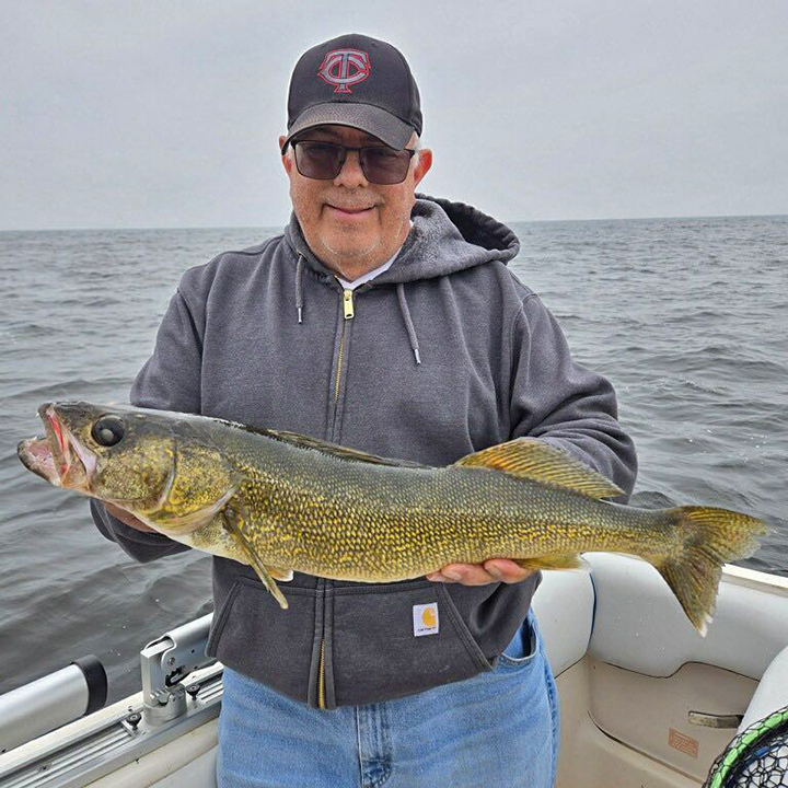 image of man on a walleye fishing charter holding a nice fish