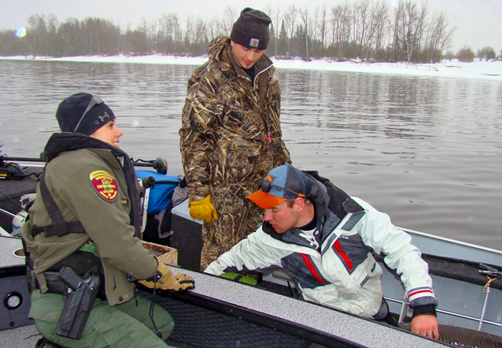image of game warden checking on anglers in fishing boat
