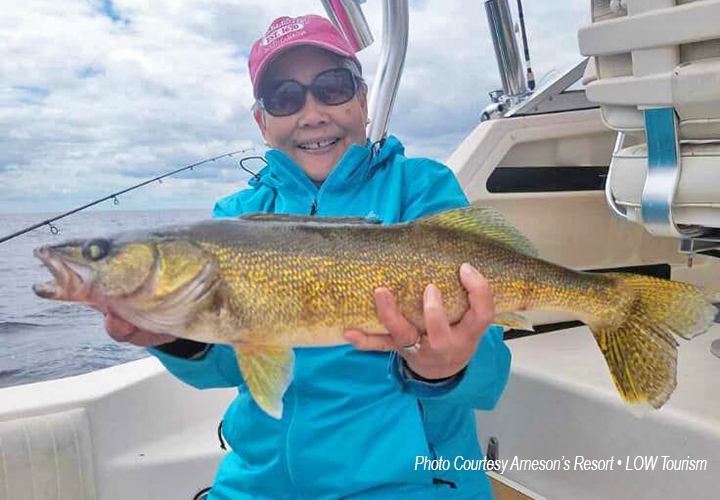 image of woman holding big walleye caught on an Arneson's Charter Fishing Trip