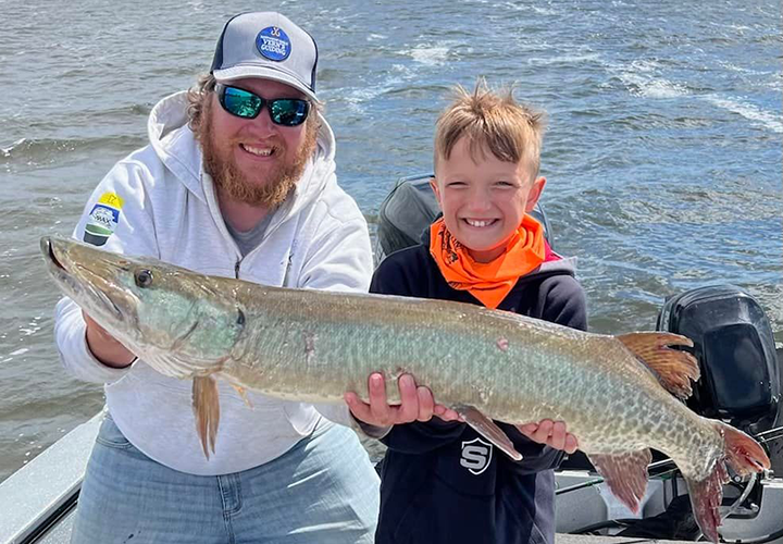 image of young boy holding his first Musky caught in the nortwest angle