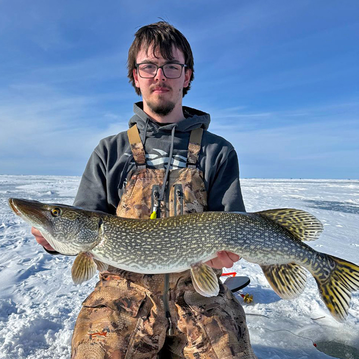 image of ice fisherman holding larger size northern pike from Lake of the Woods