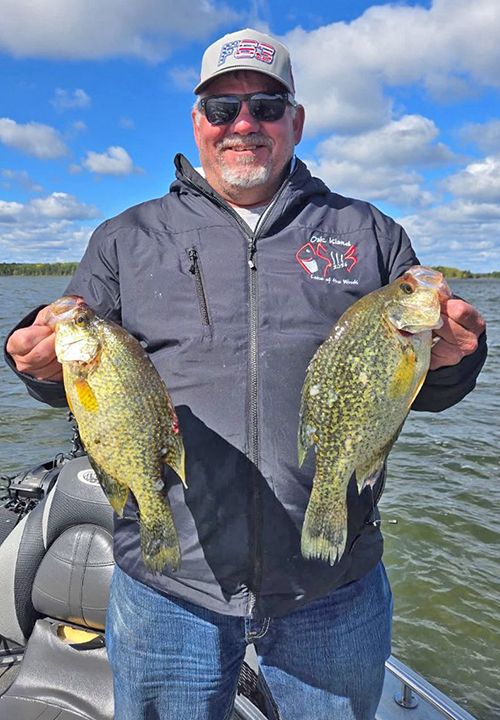 image of fisherman in the Nortwest Angle holding 2 huge crappies