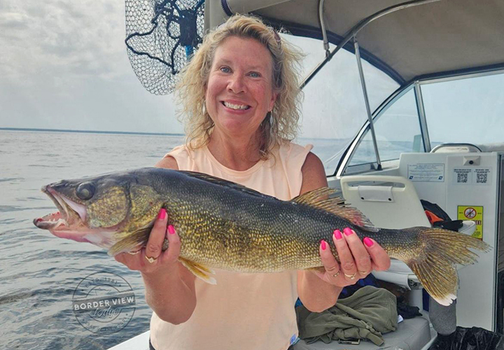 image of woman holding large walleye she caught while fishing on Lake of the Woods