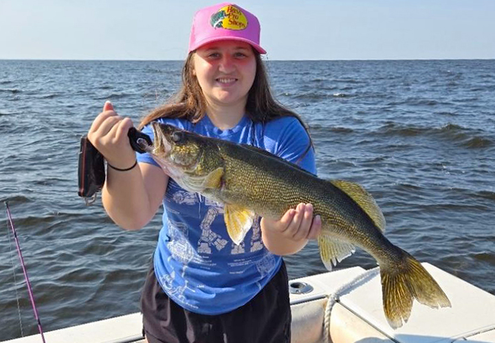 image of young woman holding big walleye on Lake of the Woods fishing charter